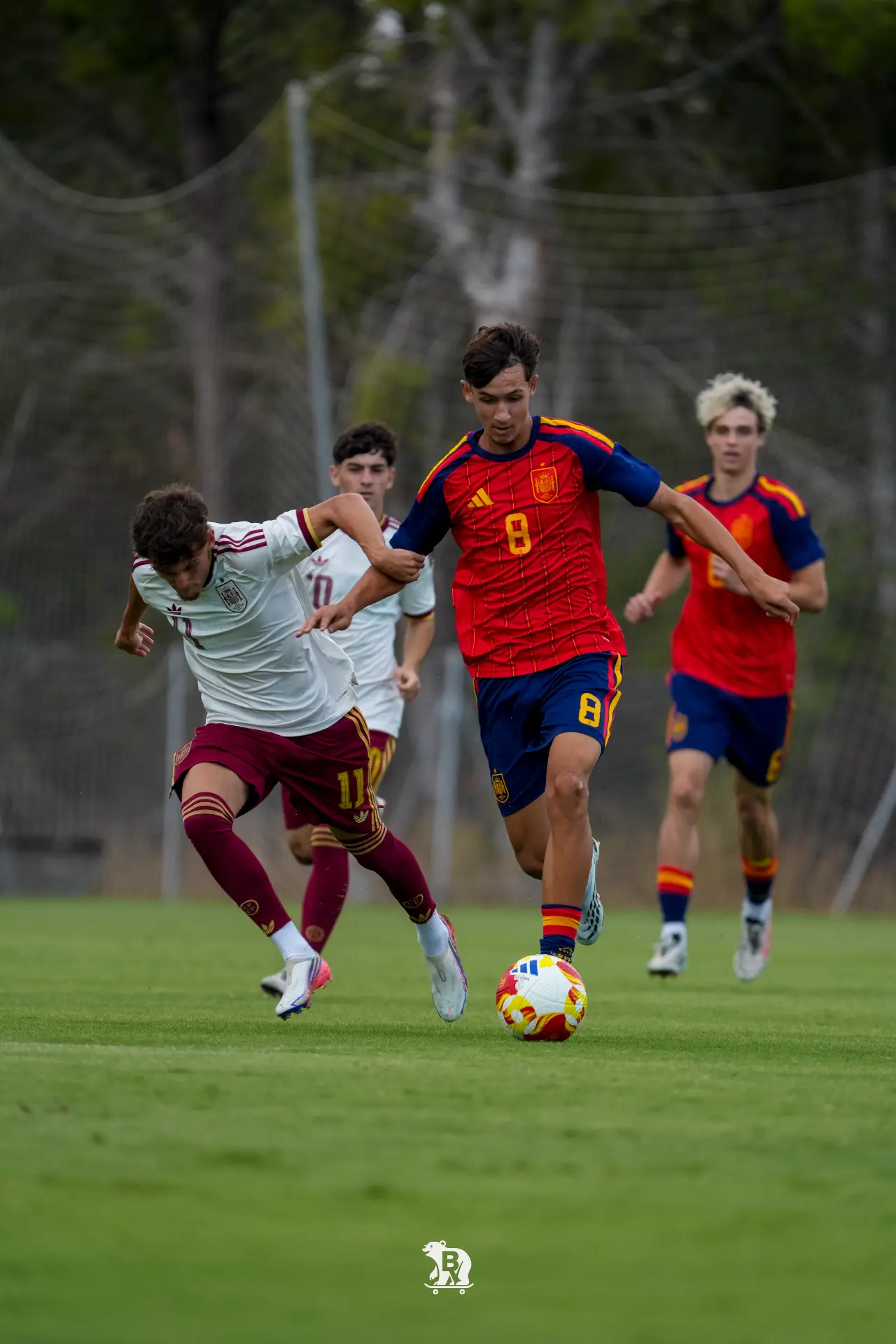 Jairo Trujillo, dorsal 8 de rojo, conduce ante la presión rival