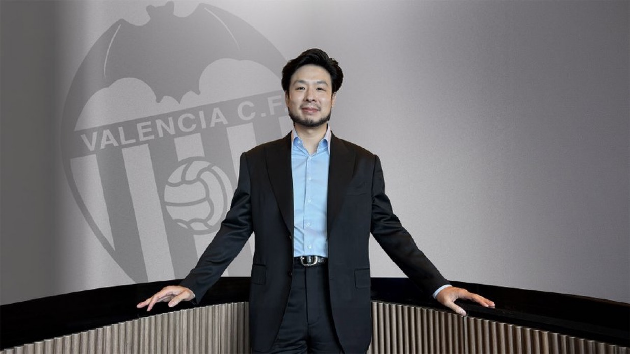 Kiat Lim, presidente del Valencia CF, posa ante el escudo del club — foto del Instagram oficial del Valencia CF