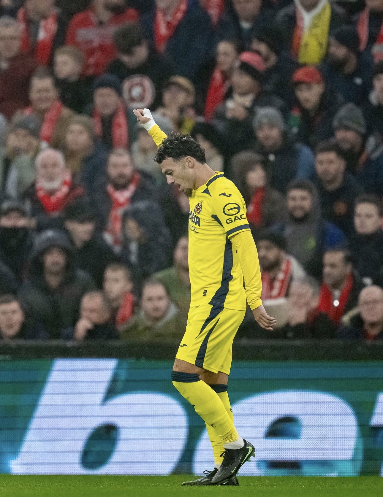 Un jugador del Villarreal levanta el puño frente a la grada de Anfield